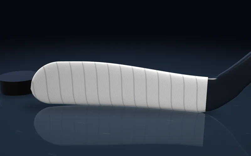 A hockey blade in thick, waxed white cloth tape with a heavy overlap.